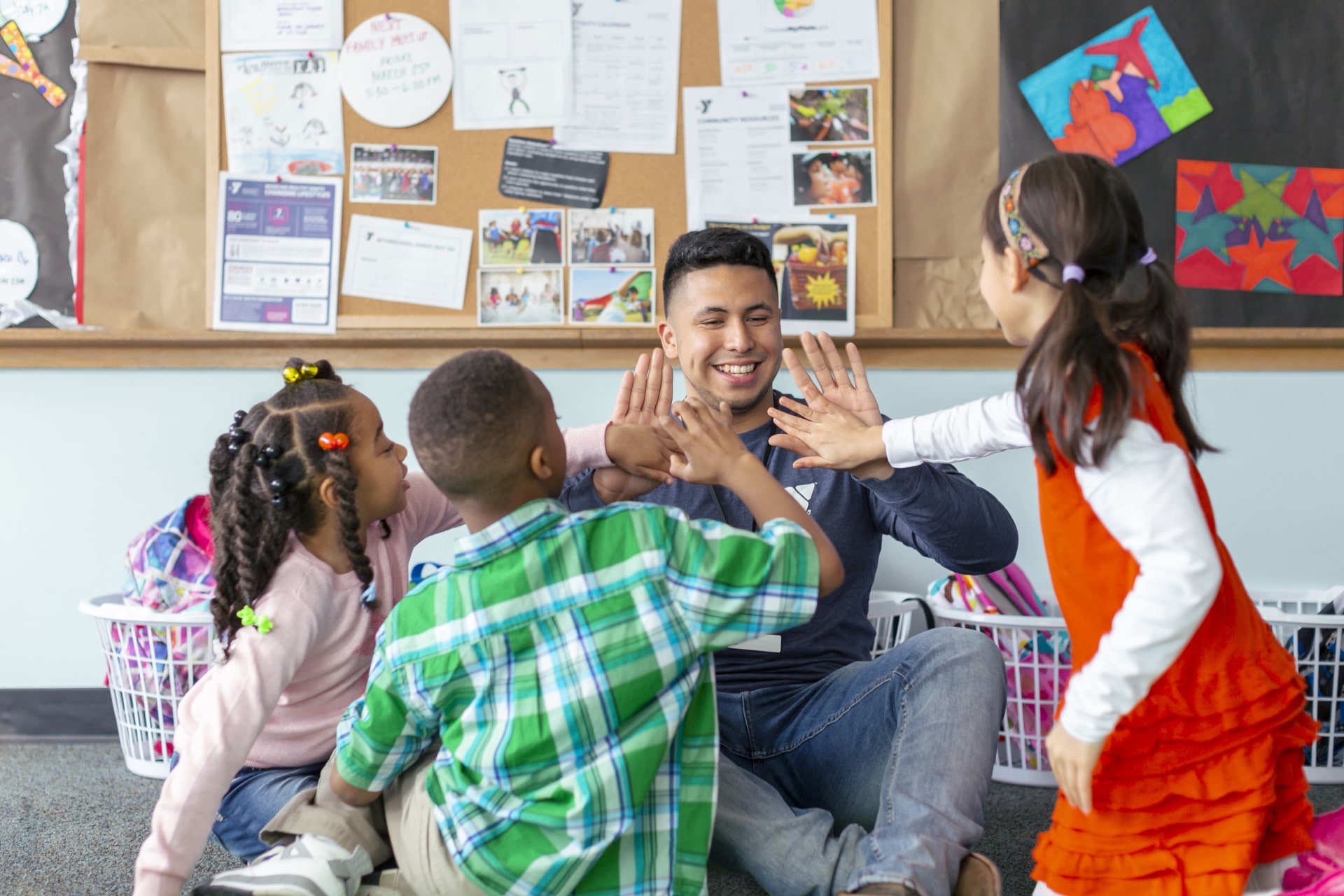 a person giving a high five to a group of children