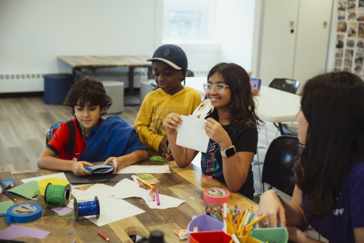 girl showing craft she made to her classmates