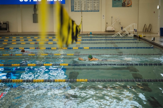 Swimmer breaststroking in lap pool.