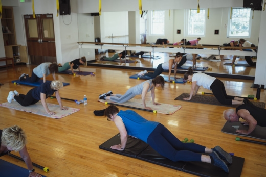 a group of people doing yoga in a gym