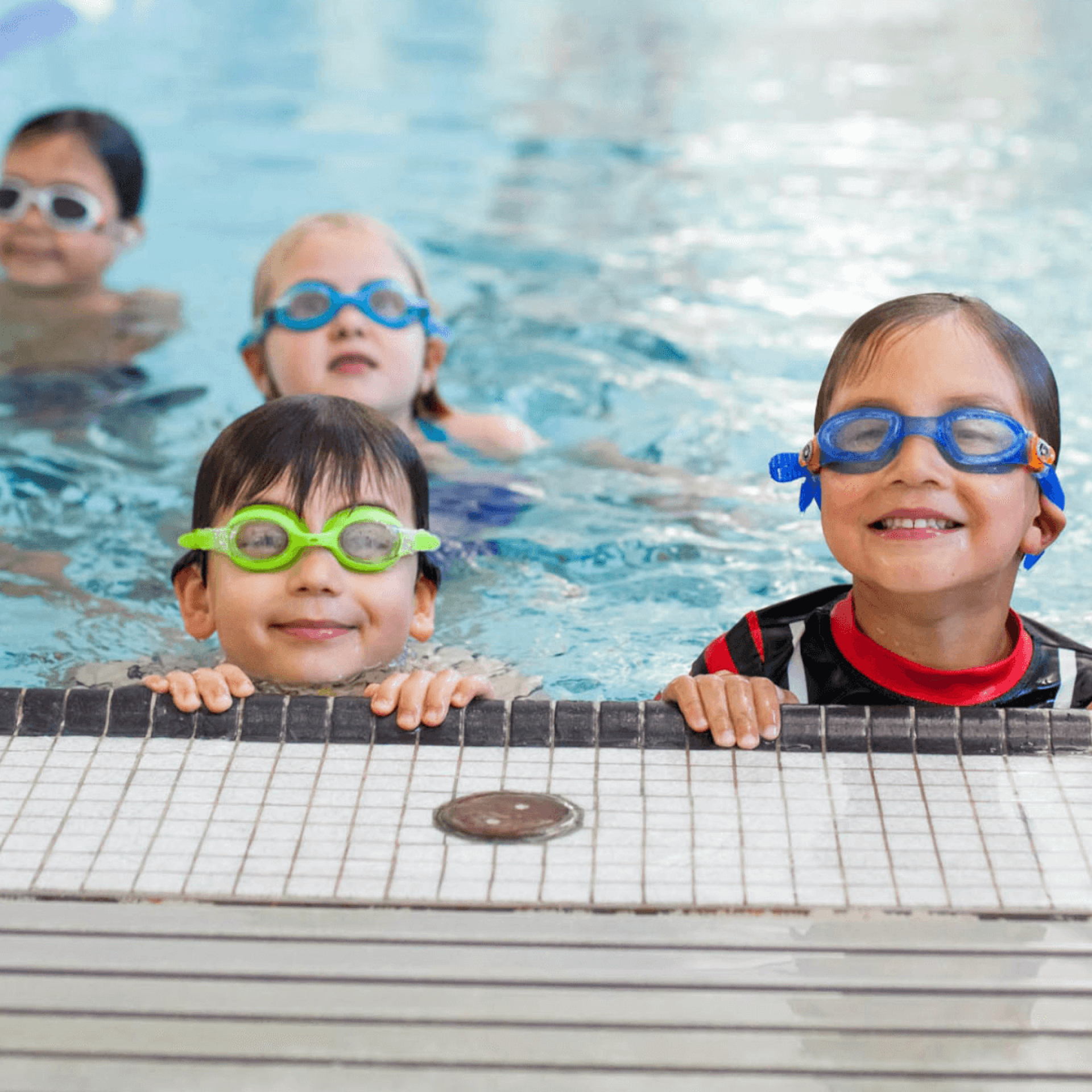 a group of children in a swimming pool wearing goggles