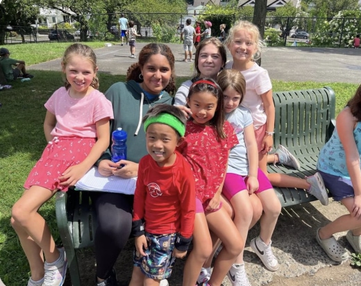 a group of children sitting on a park bench