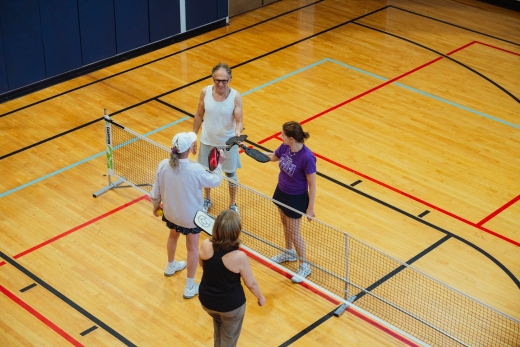 a group of people standing on top of a tennis court