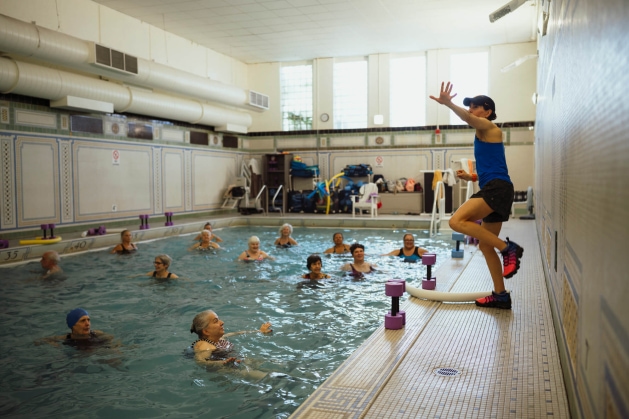 a woman in a blue tank top is in a swimming pool