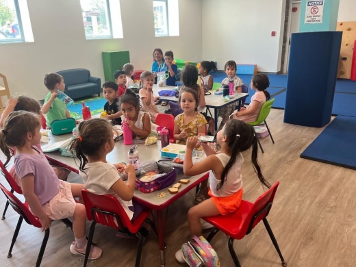 a group of children sitting around a table eating food