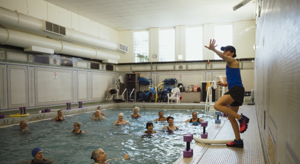 a woman in a blue tank top is in a swimming pool