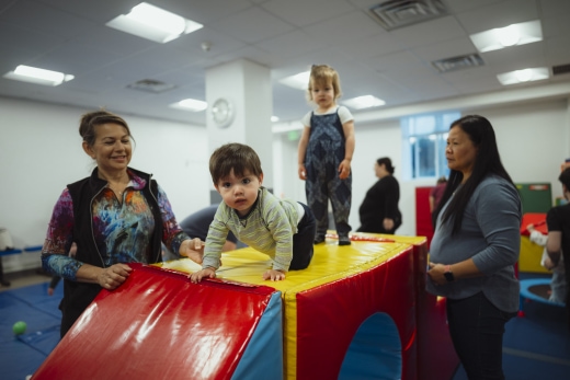 a group of people standing around a child on top of a slide