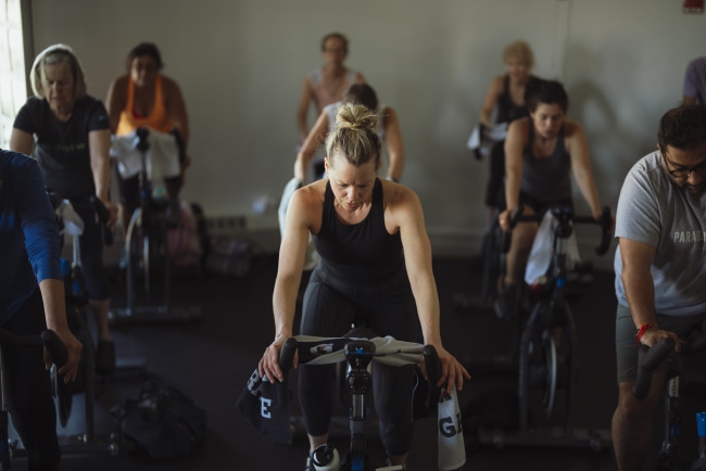 a group of people riding bikes in a gym