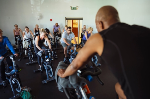 a group of people riding stationary bikes in a gym