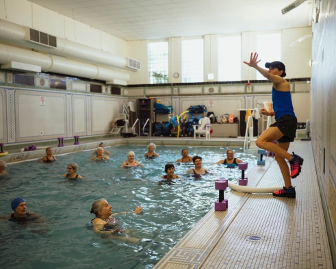 a woman in a blue tank top is in a swimming pool