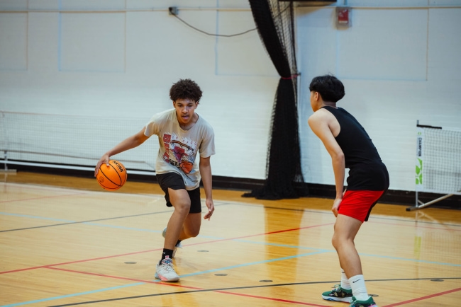 two young men playing a game of basketball