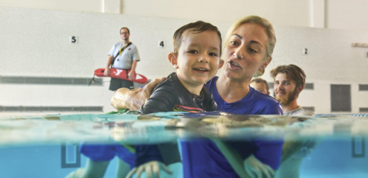 a woman and a boy are swimming in a pool