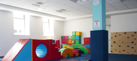 an indoor play area with a slide and climbing wall