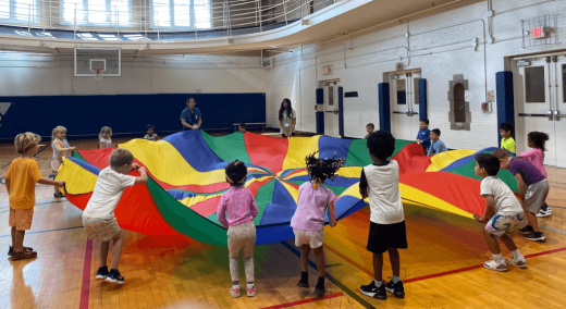 a group of children standing around a colorful kite