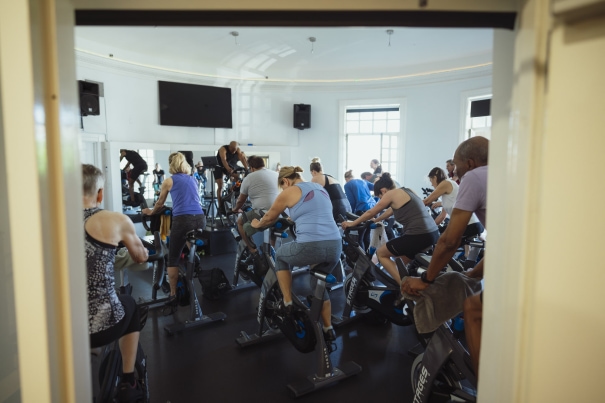 a group of people riding stationary bikes in a gym